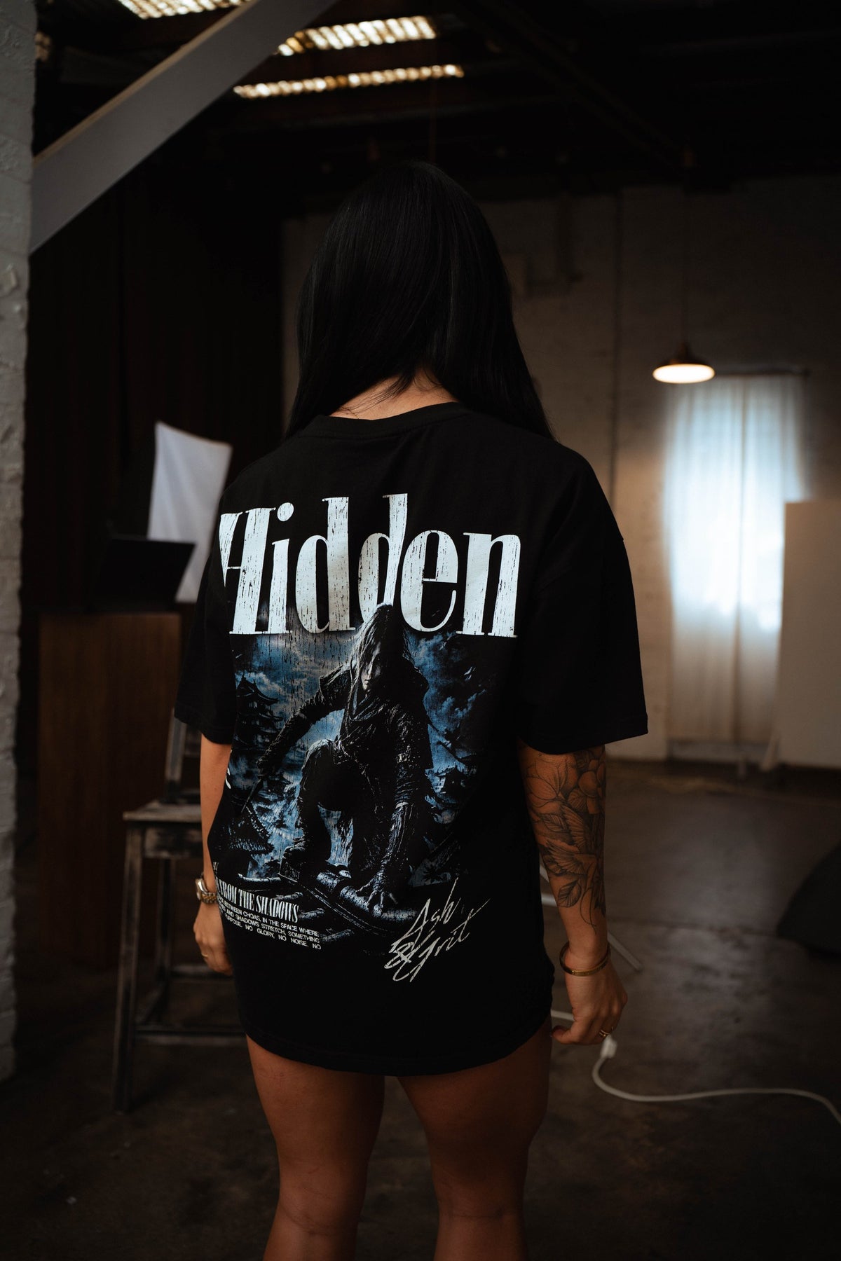 Hidden T-Shirt back graphic worn by a female model in the studio